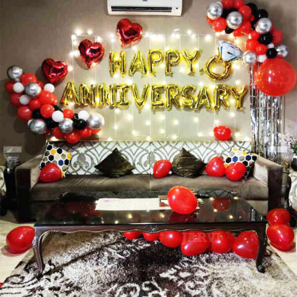 happy anniversary decoration with alphabet letter, ring shape foil balloon, fairy light, foil curtain and heart shape balloons on floor