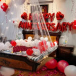 Anniversary decoration with bed canopy, heart foil balloon, tea light candle and rose petals