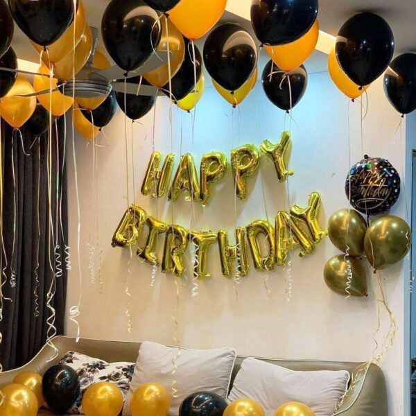 Simple birthday decoration with 2 heart/star-shaped foil balloons, 50 air-filled metallic balloons on ceiling with ribbon, and 10 metallic balloons spread on the floor and happy birthday foil balloon alphabet letter