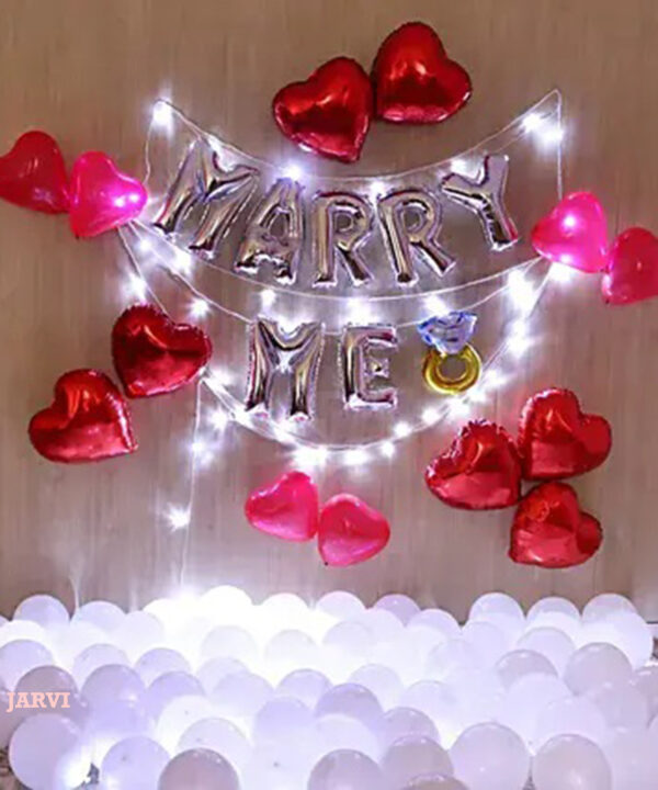 Wedding proposal decoration with heart shaped foil balloons, white balloons spread on the floor and led light string