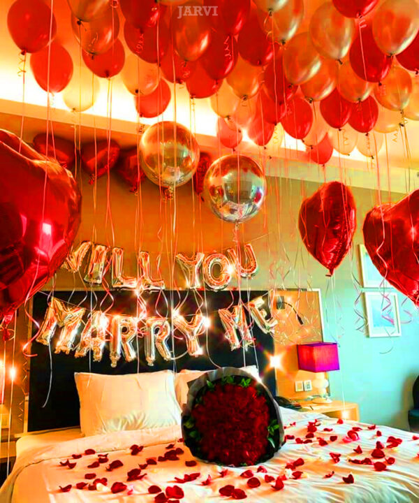 Marriage proposal decoration with will you marry me foil, rose petals on bed and floor, red and silver balloons, heart shape foil, wrinkle ribbon and rose bouquet