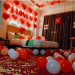 proposal balloon decoration with i love you red alphabet foil balloons, heart foil, red balloons hanging from the ceiling and spread on the bed