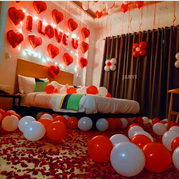 proposal balloon decoration with i love you red alphabet foil balloons, heart foil, red balloons hanging from the ceiling and spread on the bed