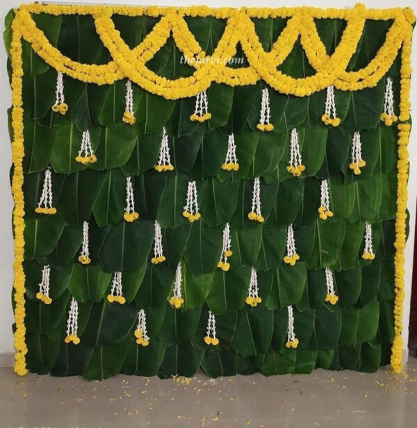 Banana leaf Haldi/Mehendi décor with natural string marigold flower all around backdrop (except ground side), 30-35 thin three Rajnigandha attached with marigold flowers and on top side two string set one side to another side.