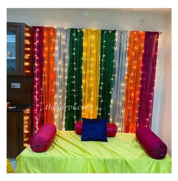 Simple Haldi/Mehandi decoration with backdrop of made of colorful mix clothes and 15-18 fairy light strings