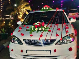 wedding car with bouquet, red roses and ribbon