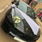 wedding car with bouquet and bonnet of car decorated with white cloth